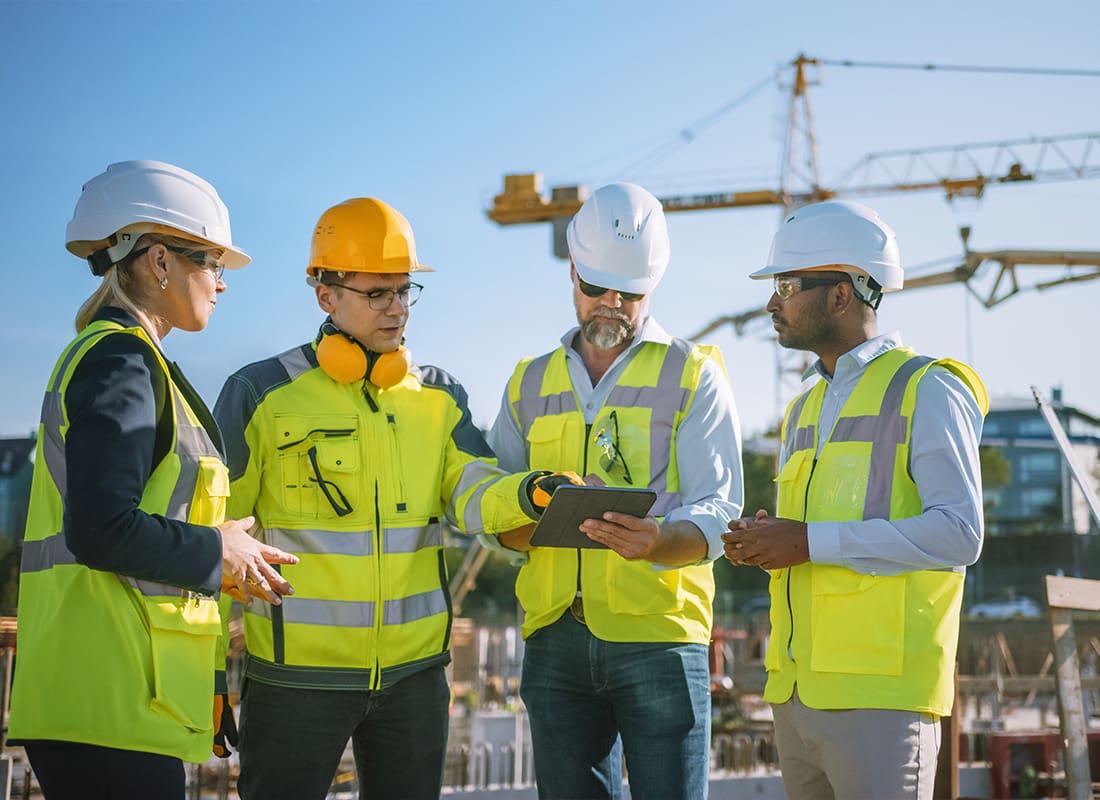 Insurance by Industry - Diverse Team of Specialists Using a Computer on a Construction Site